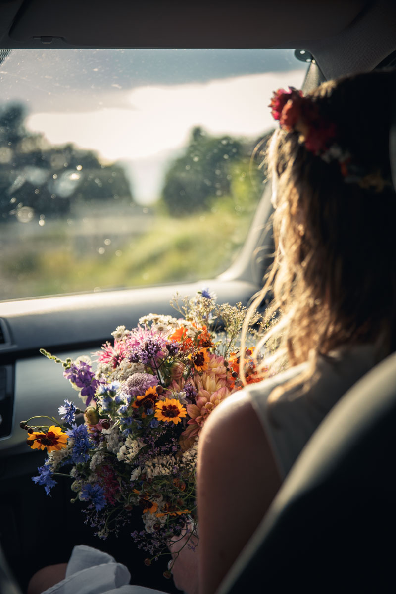 Martina in the co-pilot seat of a car carrying the wedding flowers