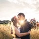 Portrait of Martina and Michele in a field with yellow grass and the sunset in the back